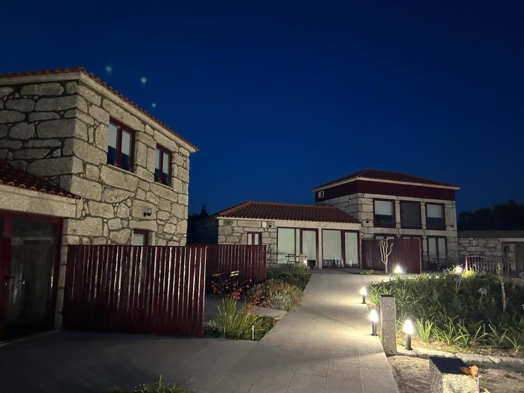 un paio di edifici in un cortile di notte di Quinta das Carvoeiras a Vieira do Minho