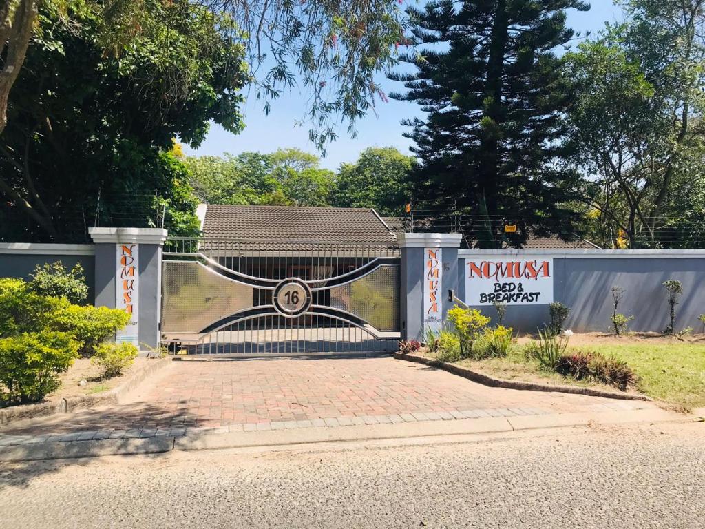 a gate to a house with a sign on it at Nomusa's Bed and Breakfast in Richards Bay