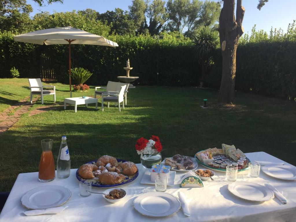 una mesa blanca con platos de comida. en Villa Simitode en Cava deʼ Tirreni