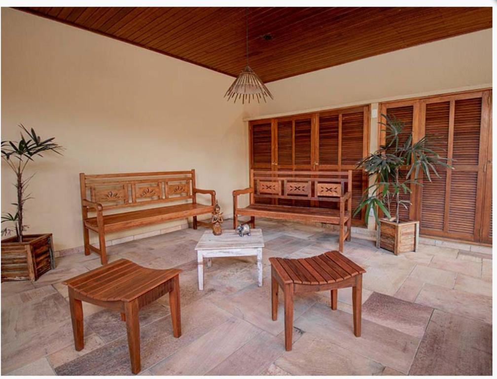 a living room with wooden benches and a table at Beira mar Flat 2-209 in Ilhabela
