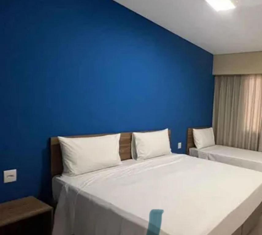 una camera da letto con un letto con una parete blu di Apto - Enjoy Water Park São Pedro a São Pedro