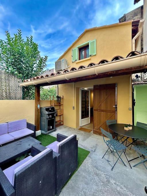 une terrasse avec un canapé et une table ainsi qu'une maison dans l'établissement Petite maison atypique à Nice, à Nice
