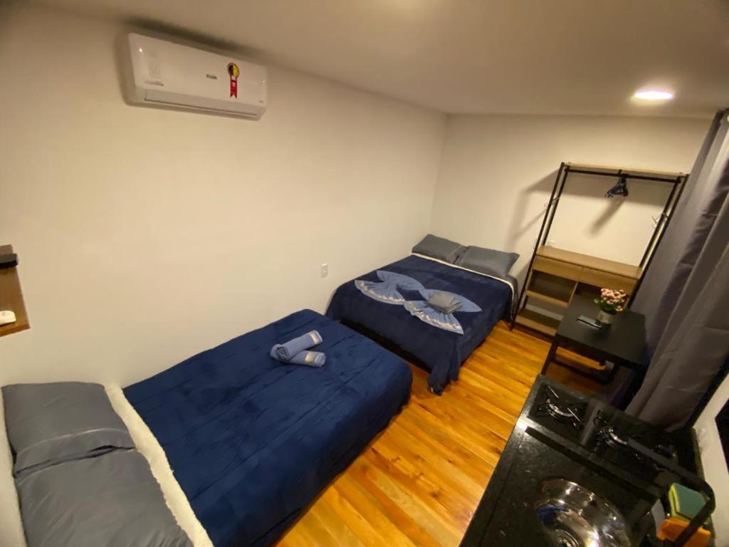 a room with two beds and a air conditioner at Cabanas Loft Paraíso in Gramado