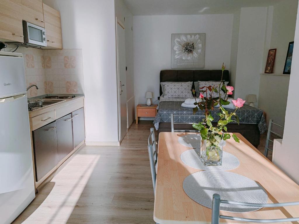 a kitchen and a living room with a table with flowers on it at Marko apartment in Rovinj