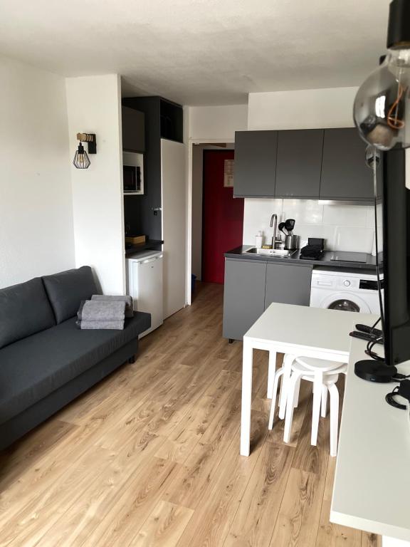 a kitchen and living room with a couch and a table at T2D Apartment - Suite BLG proche Disneyland Paris in Bussy-Saint-Georges