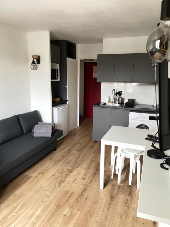 une cuisine et un salon avec un canapé et une table dans l'établissement T2D Apartment - Suite BLG proche Disneyland Paris, à Bussy-Saint-Georges