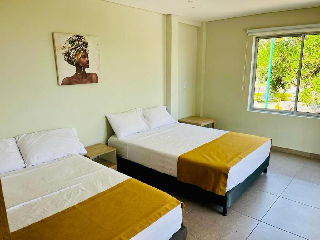 a hotel room with two beds and a window at Hotel Payara in Puerto Gaitán