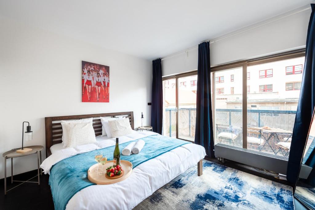um quarto com uma cama e uma grande janela em Lux apartments with an elegant balcony Prague em Praga