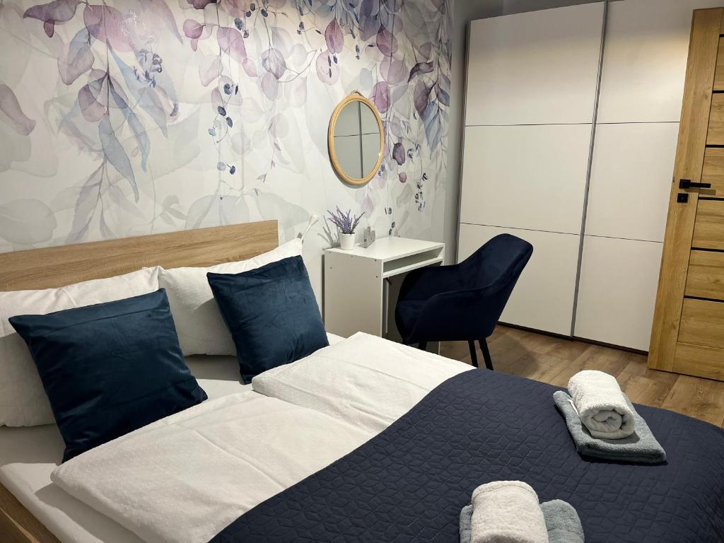 1 dormitorio con 1 cama grande con almohadas azules en Nowy Apartament en Świnoujście
