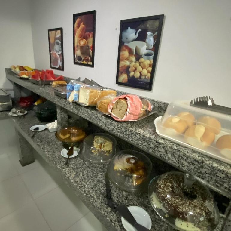 una línea de buffet con muchos tipos diferentes de comida en Hotel dos viajantes, en Sorriso