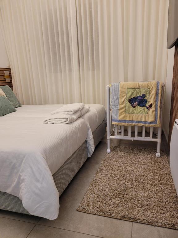 a bedroom with two beds and a baby crib at Jerusalem Center in Jerusalem