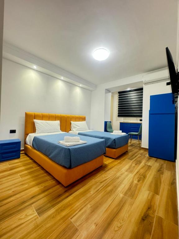 Keli’s apartment في تيرانا: سريرين في غرفة ذات أرضيات خشبية