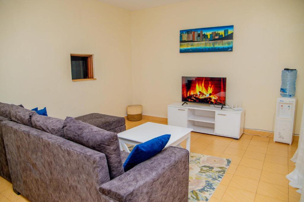 ein Wohnzimmer mit einem Sofa und einem TV in der Unterkunft Ranny Homes Kisii in Kisii