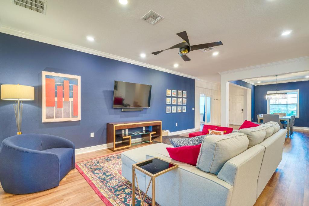 sala de estar con sofá blanco y pared azul en Brooksville Home - 12 Mi to Weeki Wachee Springs!, en Brooksville