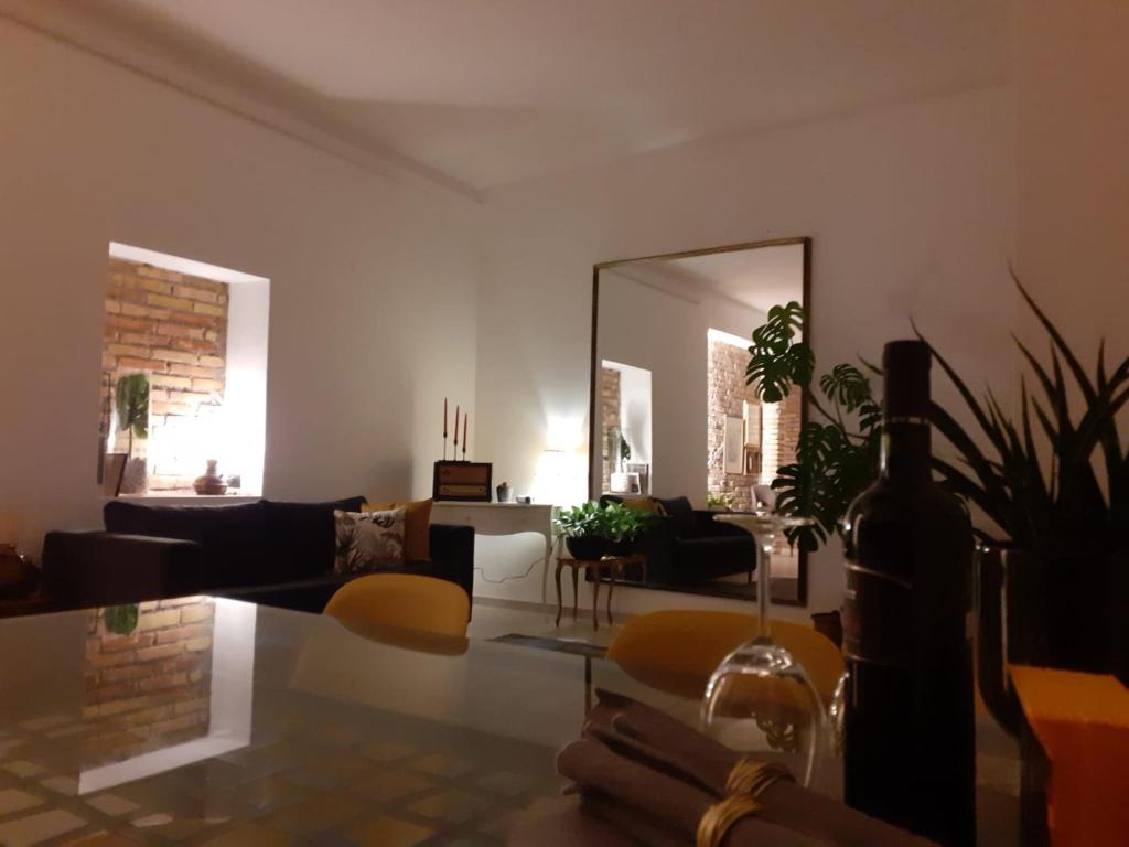 sala de estar con sofá y espejo en L'Archetto Apartment, en Civitavecchia