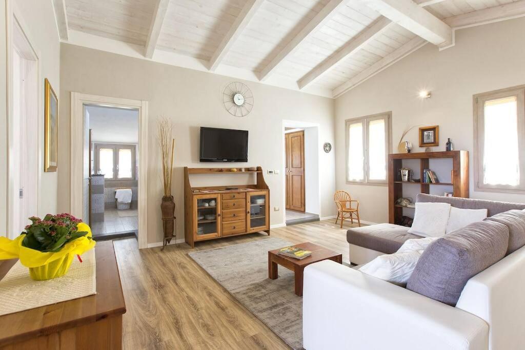a living room with a couch and a tv at ClickSardegna Villa dei Limoni with pool close to the beach in Fertilia