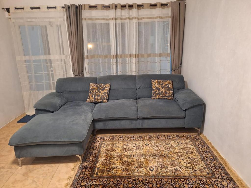 ein blaues Sofa im Wohnzimmer mit Fenster in der Unterkunft SB Villa in Triolet