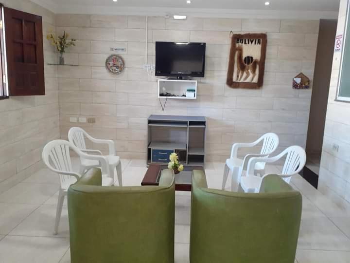 a living room with white chairs and a tv at Sonho dos golfinhos in Recife