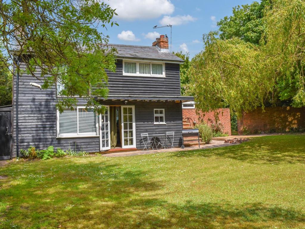 a black house with a yard in front of it at Hollybush Studio - Uk39054 in Knebworth