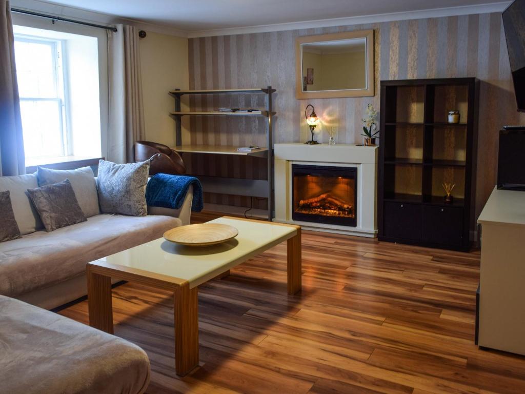 a living room with a couch and a fireplace at Lochside Apartment in Inveraray