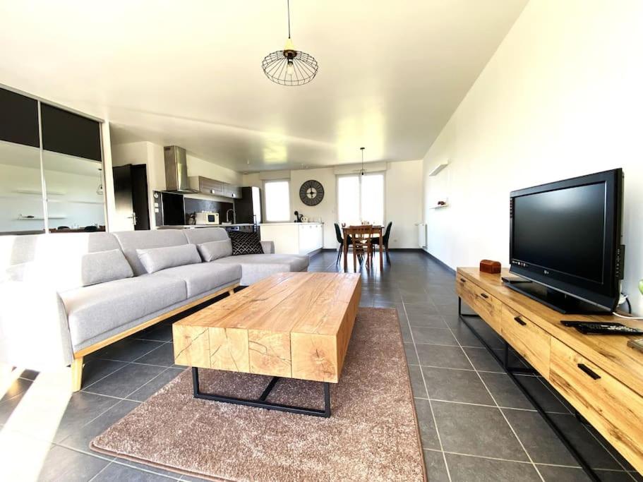 a living room with a couch and a flat screen tv at La belle des champs in Luzillé