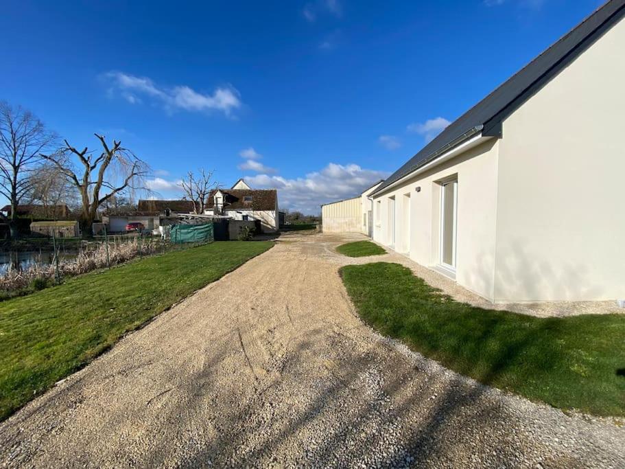 a dirt road next to a white building at La belle des champs in Luzillé