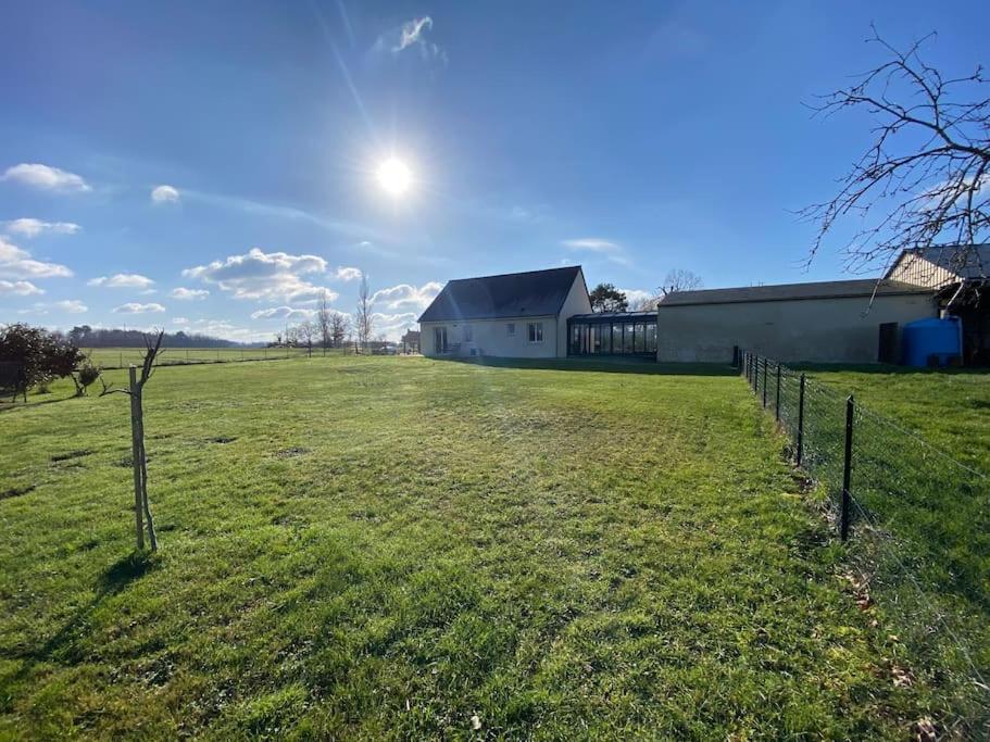 a field with a fence in front of a building at La belle des champs in Luzillé