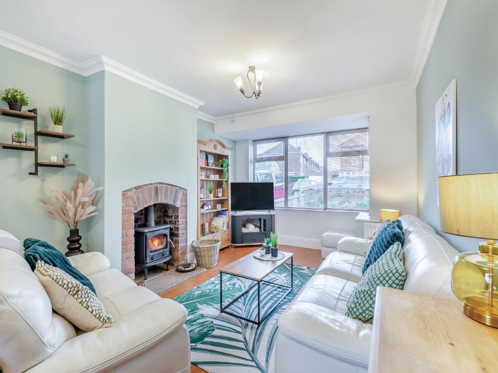 a living room with white furniture and a fireplace at 25 Appledore Gardens in Chester-le-Street