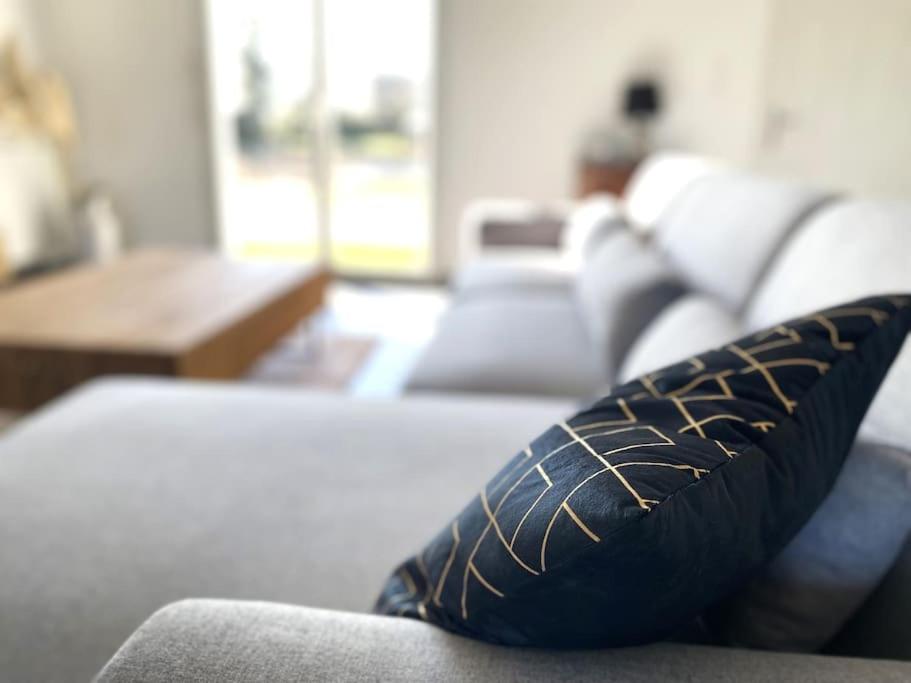 a pillow sitting on a couch in a living room at La belle des champs in Luzillé