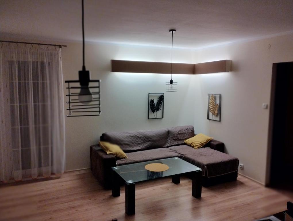 a living room with a couch and a table at Green Apartment in Olsztyn