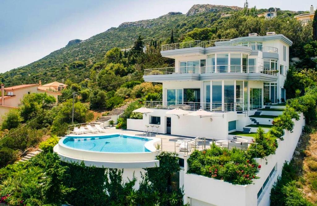 ein großes weißes Haus mit einem Pool in der Unterkunft Villa Coral Luxury Resort in Agios Spyridon