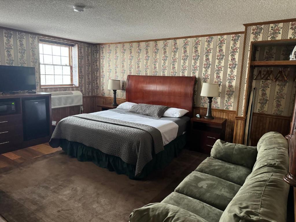 - une chambre avec un lit et un canapé dans l'établissement Fenway House Hotel, à Fennimore