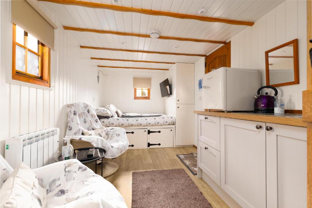 a hospital room with a bed and a desk and chairs at Shepherds Hut, West Ayton, Scarborough in Scarborough