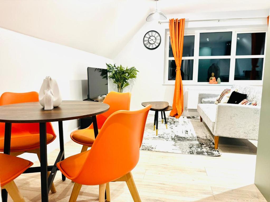 a living room with orange chairs and a table at Dover luxury apartments, near Ferry in Dover