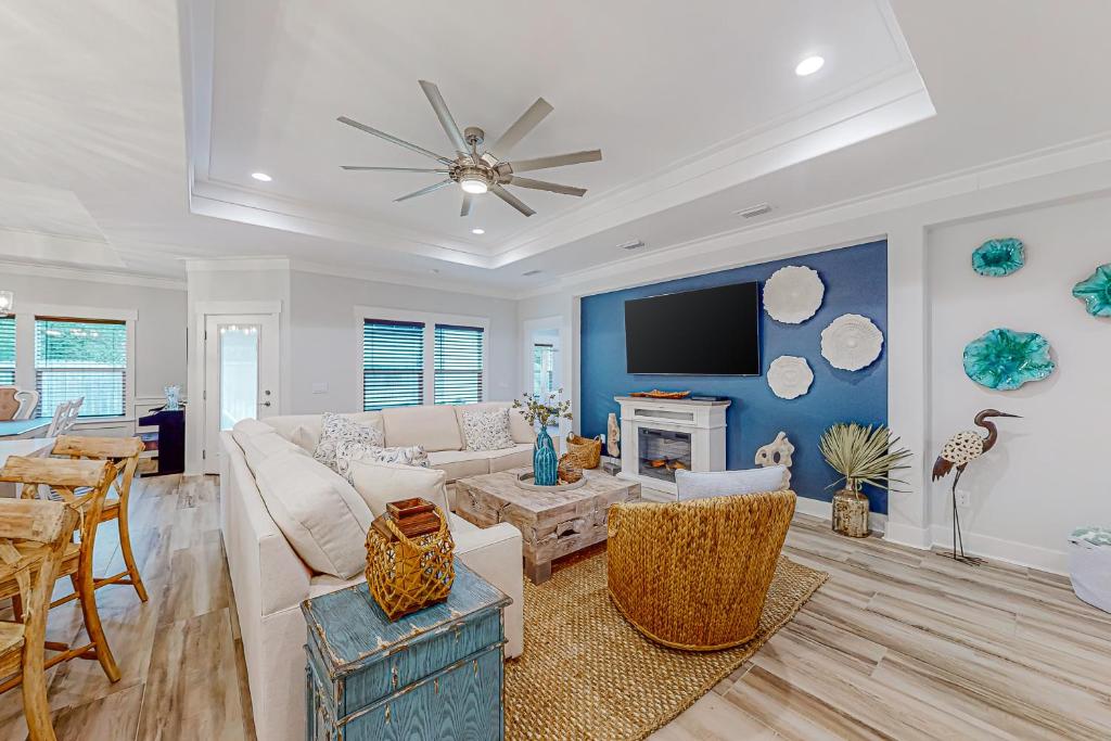 a living room with a couch and a tv at Driftwood Dreams in Panama City Beach