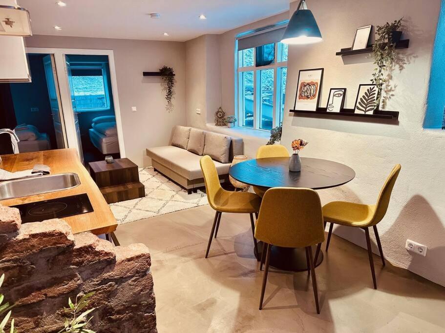 een woonkamer met een tafel en stoelen en een bank bij Apartment close to downtown in Akureyri