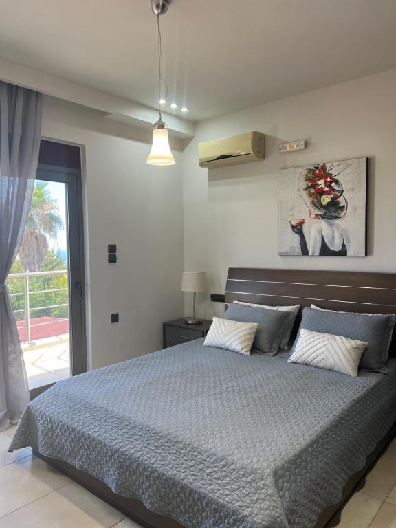 1 dormitorio con 1 cama con edredón azul en Villa Chrysa Rhodes, en Afantou