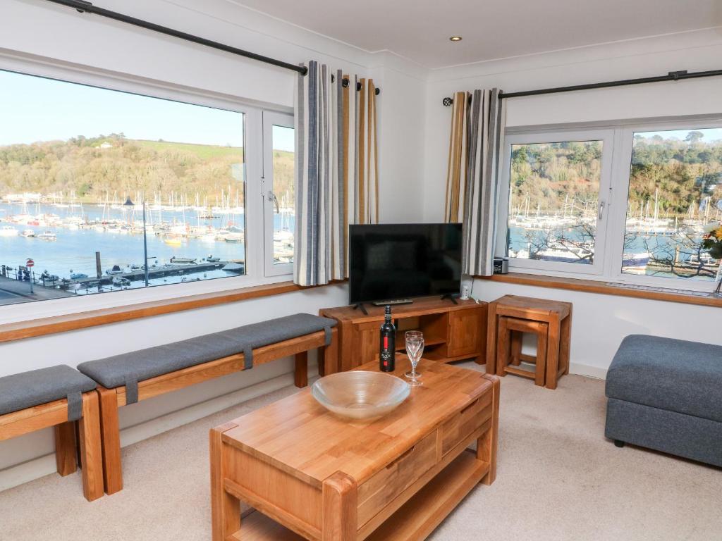 a living room with a couch and a tv and windows at Leeward in Dartmouth
