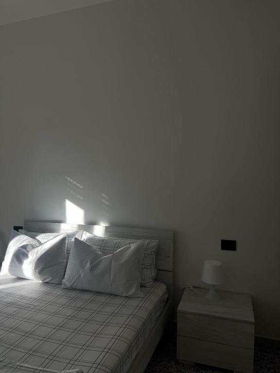 ein Schlafzimmer mit einem Bett und einem Nachttisch mit einer Lampe in der Unterkunft YellowHouse in Gallarate
