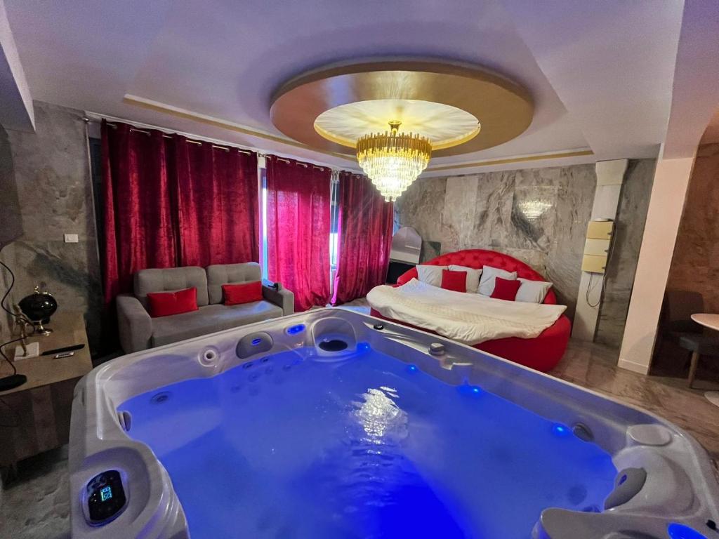 eine Badewanne in einem Zimmer mit einem Bett in der Unterkunft Golden Love - Jacuzzi in Rouen