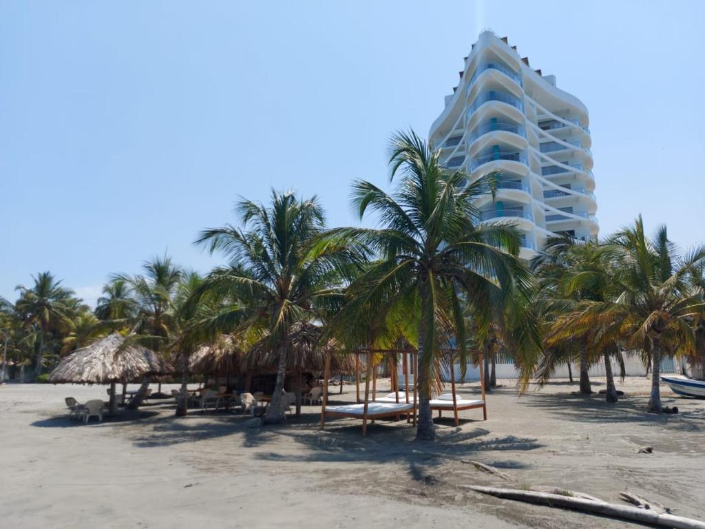 a hotel on the beach with palm trees at Apartamentos Mi Reserva OK - Fontaine Bleu in Coveñas