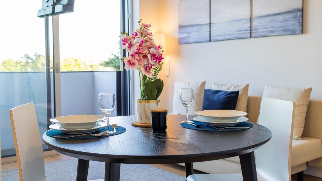 a dining room table with two glasses and a vase with flowers at Nice Circunvalação Studio II By Unique Hosts in Senhora da Hora