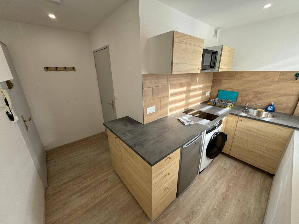 une petite cuisine avec un évier et une cuisinière dans l'établissement Studio calme à 15min du centre, à Strasbourg