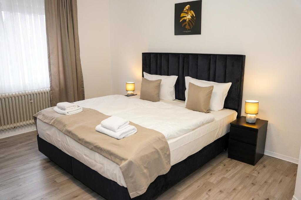 a bedroom with a large white bed with two lamps at GN Hotel Furpach in Neunkirchen