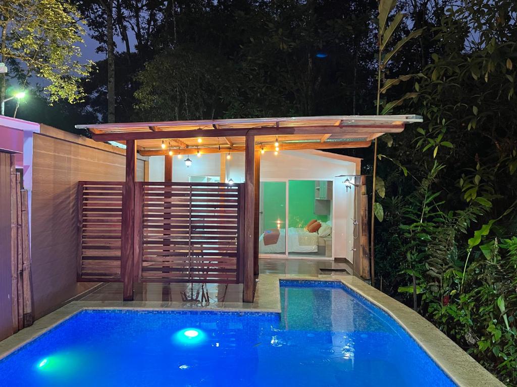 una piscina con pérgola junto a una casa en Subtropica Premium Suites - Mindo, en Mindo