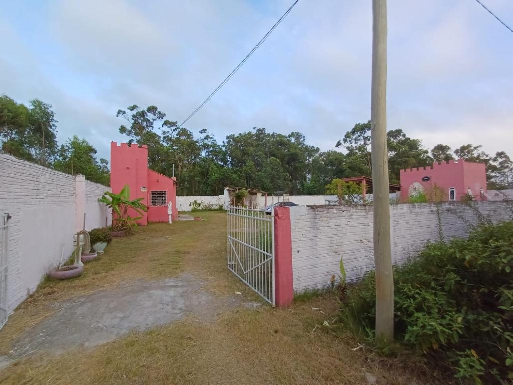 a compound with pink houses and a fence at Casa do Mato I in São Lourenço do Sul