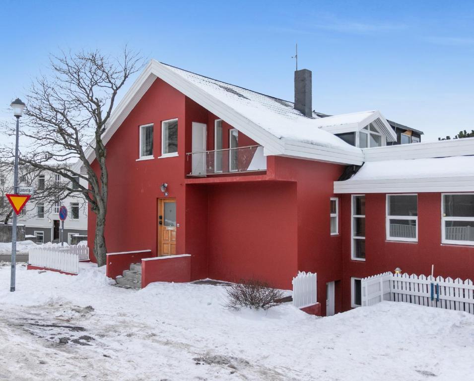 une maison rouge avec de la neige au sol dans l'établissement Stay Iceland apartments - U 16, à Reykjavik