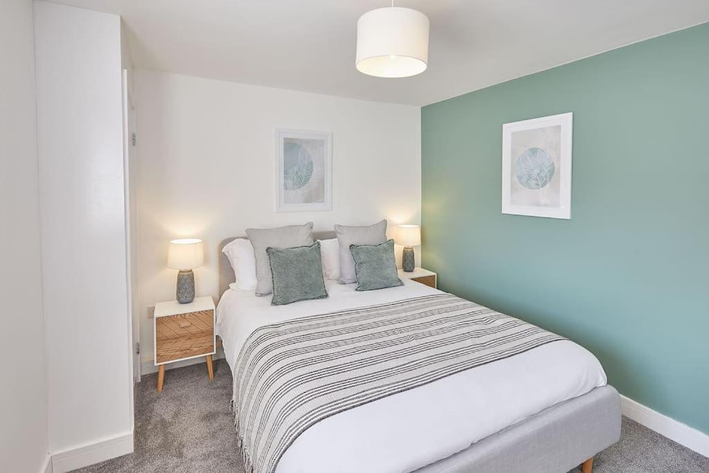 a bedroom with a large white bed with green pillows at Spacious Seaview 1 Bedroom Apartment in Redcar