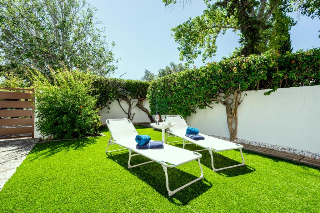 three lounge chairs on the grass in a backyard at Vilamoura Garden House - Golf & Beach in Vilamoura