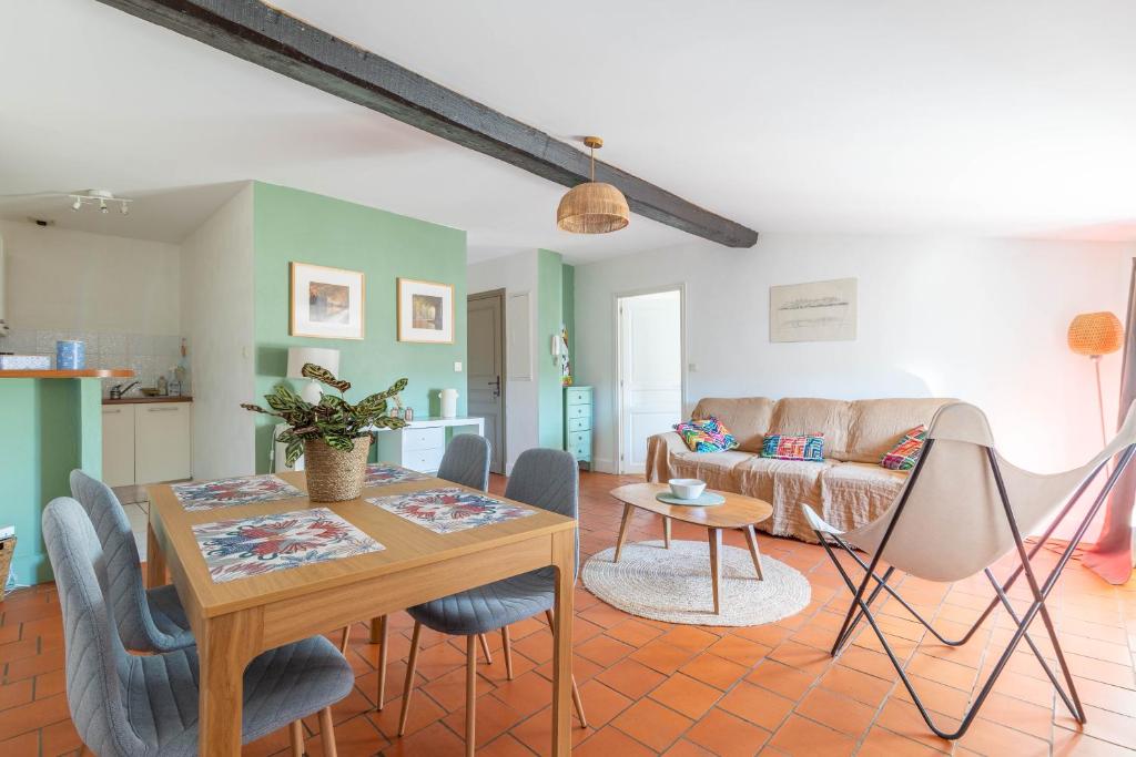 un salon avec une table, des chaises et un canapé dans l'établissement Bel Appartement avec cour au cœur de la Bastide, à Carcassonne